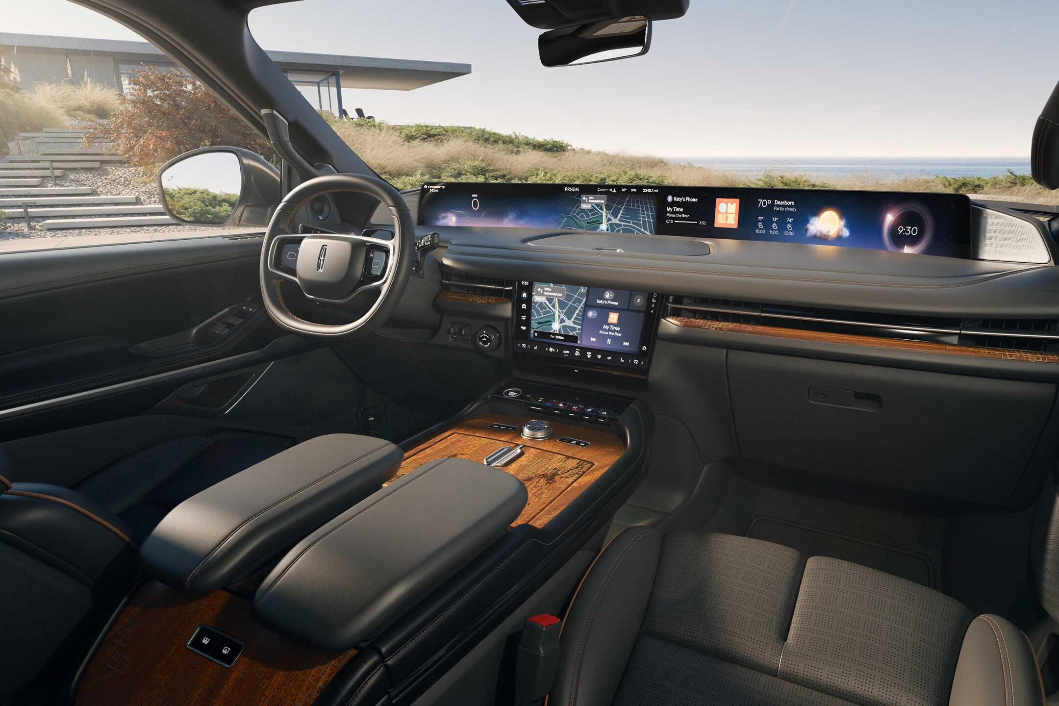 Interior cabin of a Lincoln Nautilus showcasing the "Invitation" theme. It features dark onyx leather upholstery paired with rich, open-pore wood accents on the center console and dashboard. The dual-screen setup is visible, highlighting the seamless integration of the panoramic display and the central touchscreen.